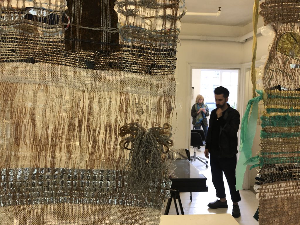 Paolo Fiorentini seen through woven tapestry by Maud Barrett and Femke Winde Lemmens with Teresa Witz in the background in preparation for the Apartment #10